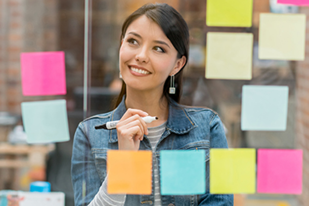woman considering various ideas on post-it notes